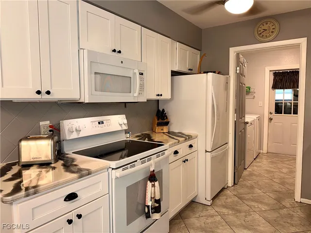a kitchen with cabinets and white appliances