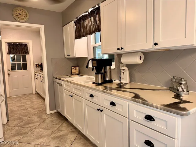 a kitchen with appliances a sink and cabinets