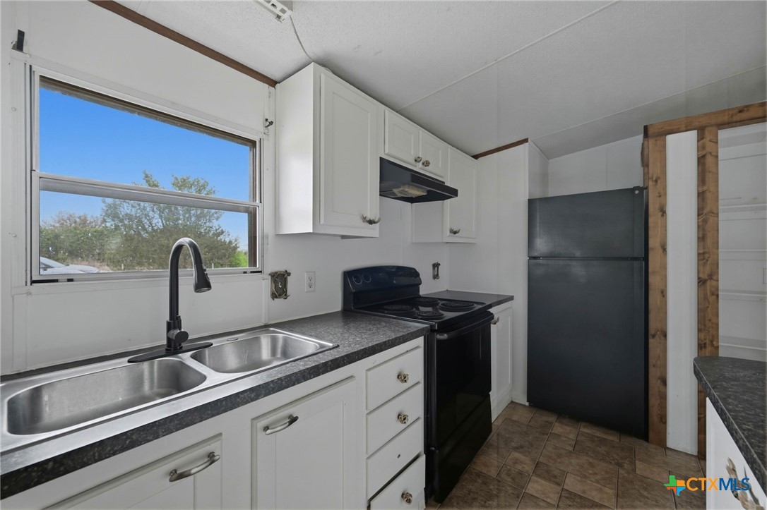 770 Private Road 3447 Kempner, TX 76539 - Photo 11 of 34 a kitchen with stainless steel appliances granite countertop a sink stove and refrigerator