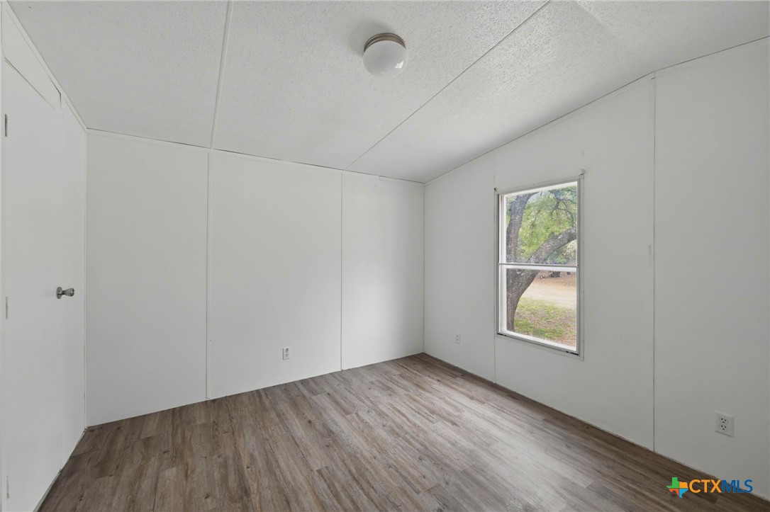 770 Private Road 3447 Kempner, TX 76539 - Photo 16 of 34 an empty room with wooden floor and windows