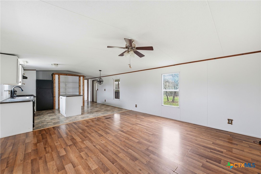 770 Private Road 3447 Kempner, TX 76539 - Photo 7 of 34 a view of a kitchen with wooden floor and a ceiling fan