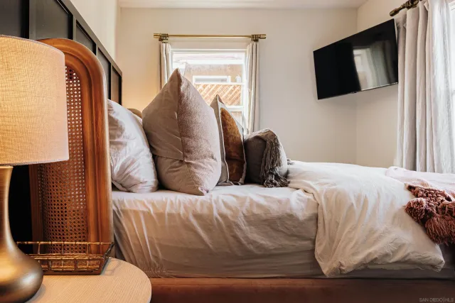 a bedroom with a bed and a painting on the wall