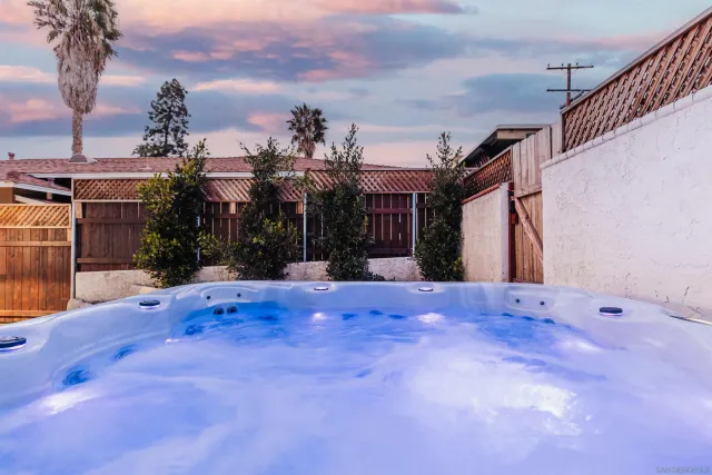 a view of a backyard with table and chairs with wooden fence