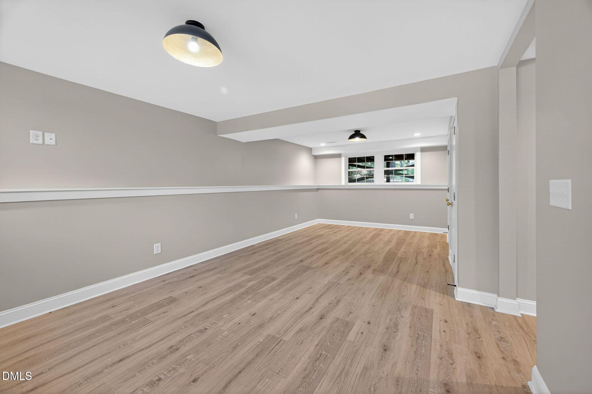 313 Crown Oaks Drive Raleigh, NC 27615 - Photo 57 of 60 an empty room with wooden floor and windows