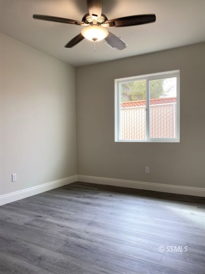 1217 Sims Street Ridgecrest, CA 93555 - Photo 21 of 35 wooden floor in an empty room with a window
