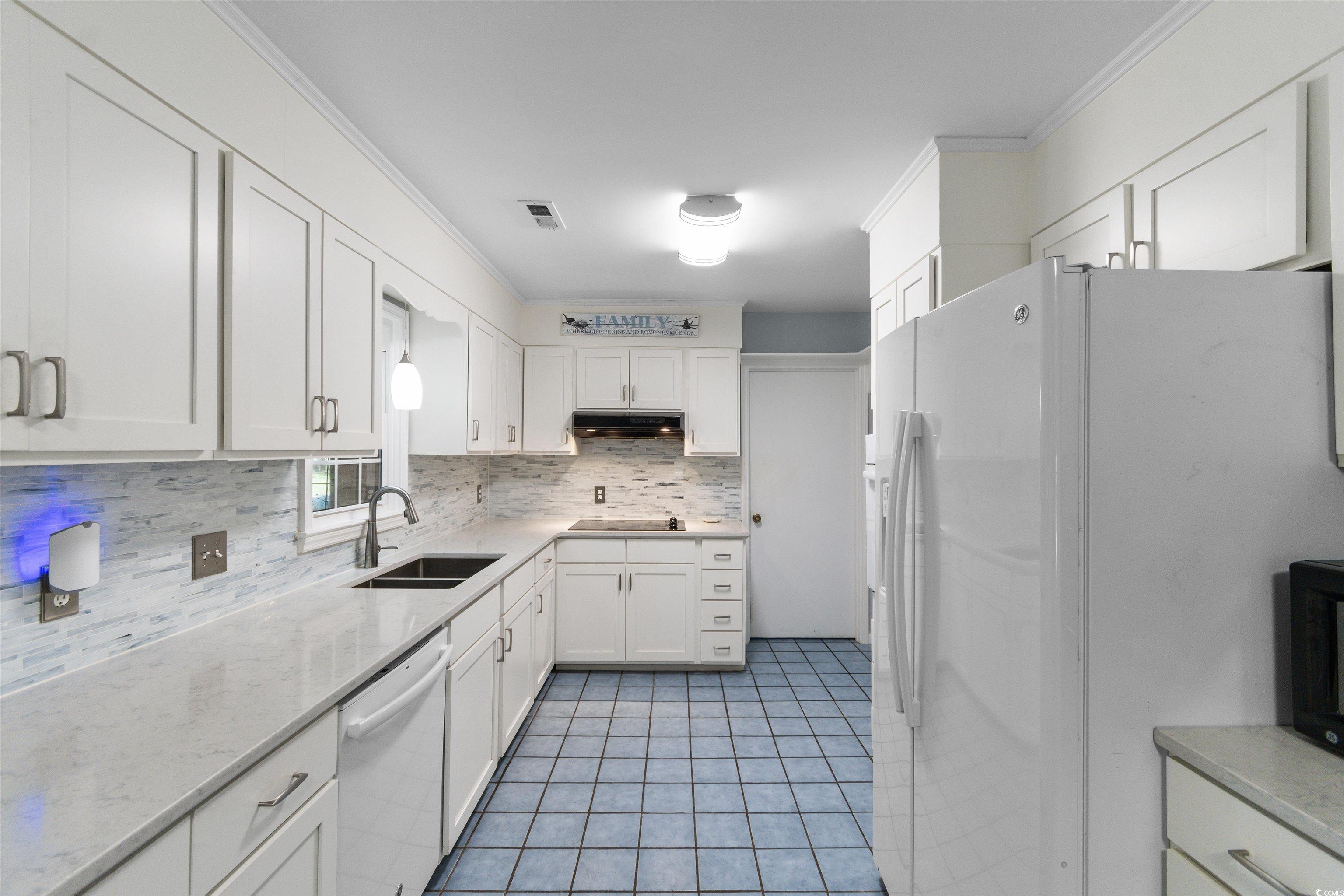 814 2nd Avenue Georgetown, SC 29440 - Photo 13 of 39 Kitchen featuring tasteful backsplash, white appliances, white cabinets, light tile patterned floors, and crown molding