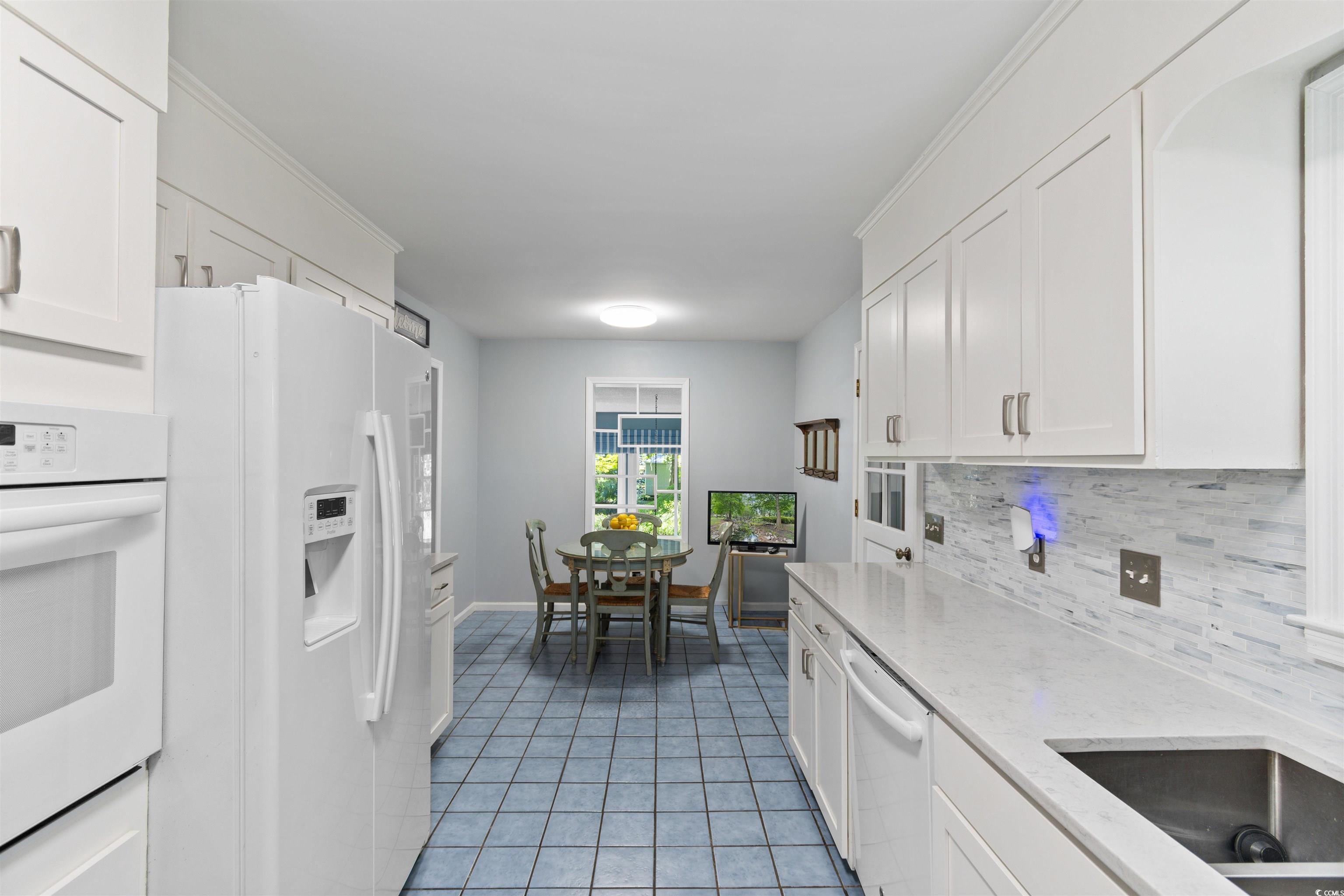 814 2nd Avenue Georgetown, SC 29440 - Photo 15 of 39 Kitchen with tasteful backsplash, white cabinets, white dishwasher, and light tile patterned floors