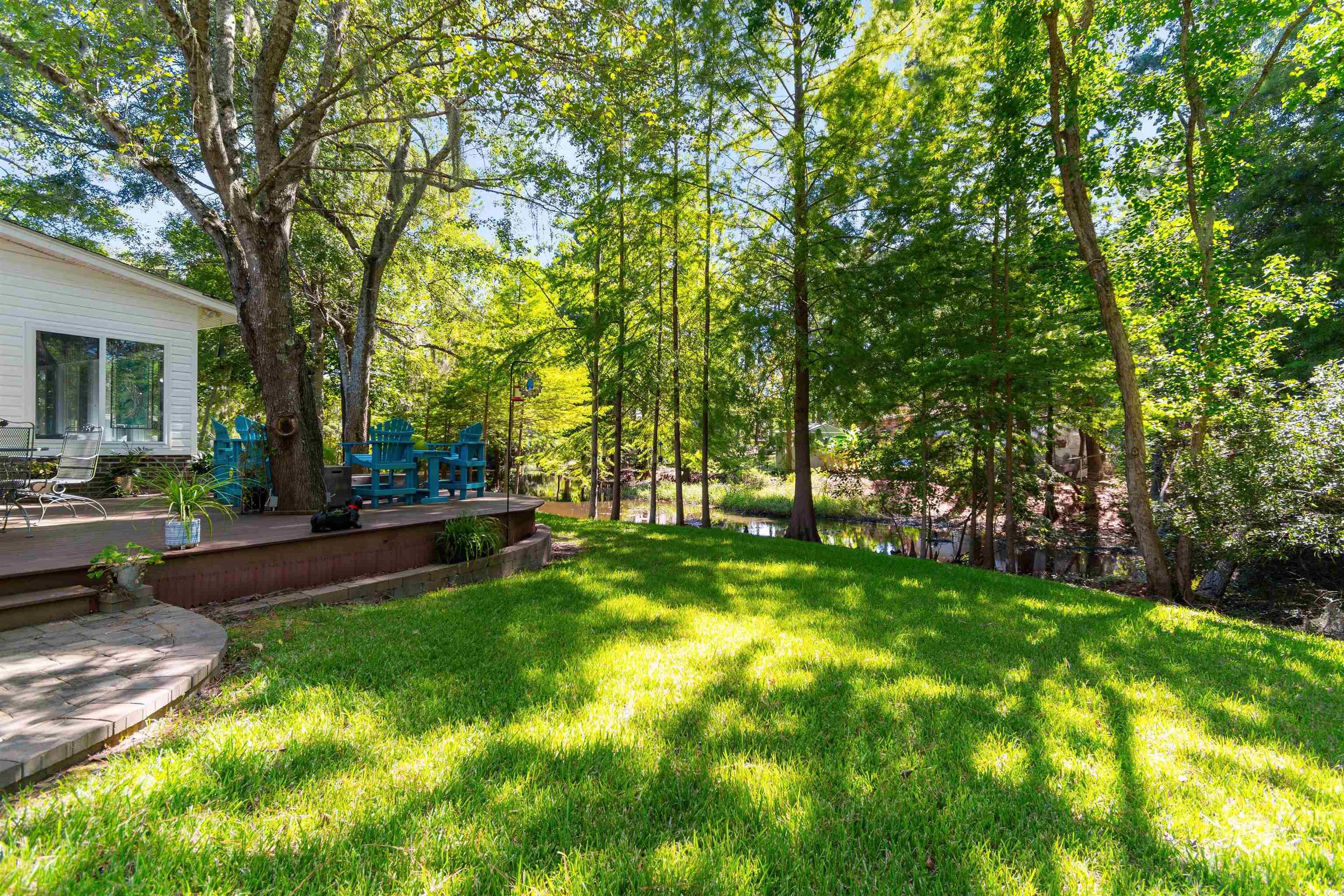 814 2nd Avenue Georgetown, SC 29440 - Photo 29 of 39 Wooden deck with outdoor dining area, view of wooded area, and a lawn