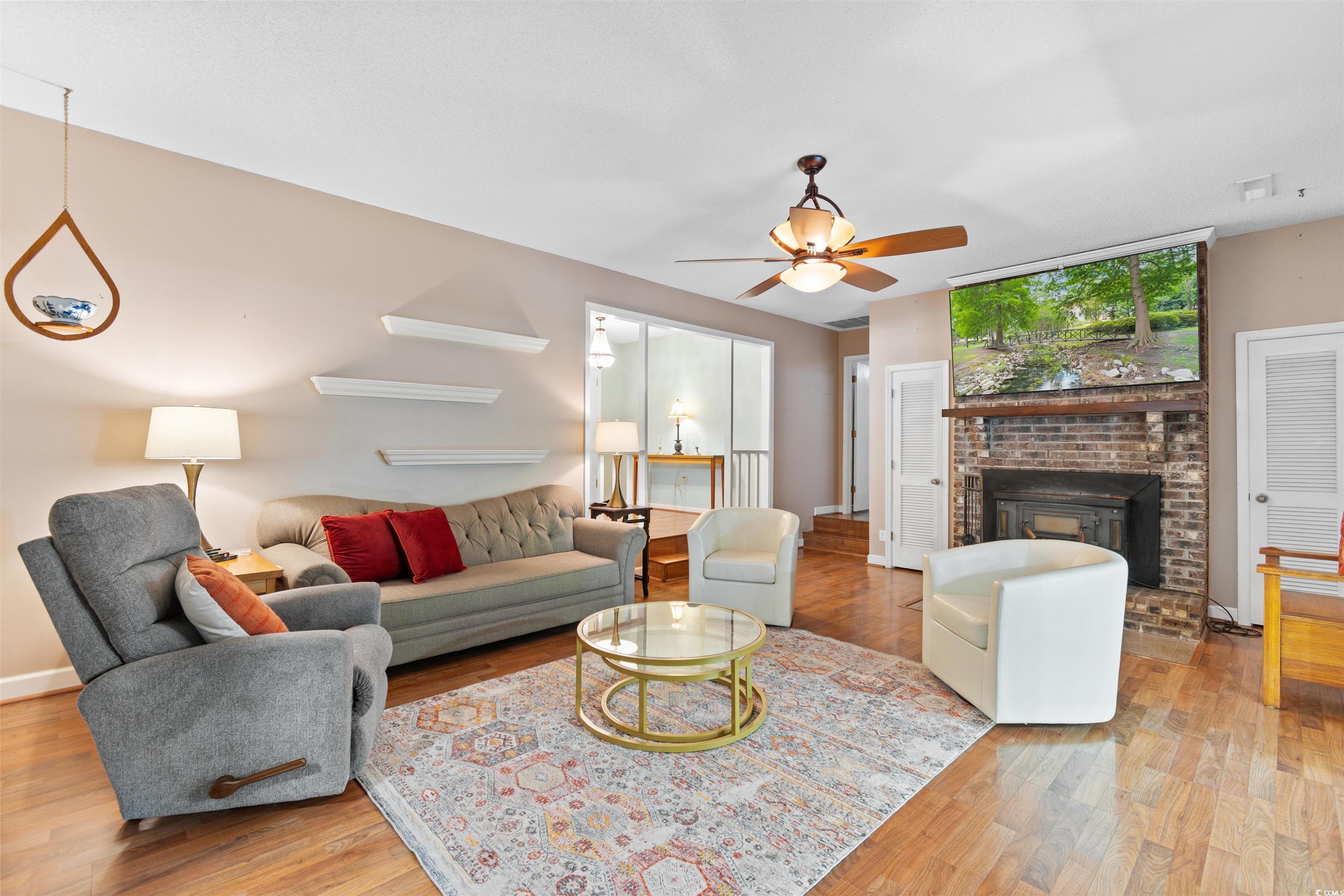 814 2nd Avenue Georgetown, SC 29440 - Photo 9 of 39 Living area with light wood-style floors, a brick fireplace, and a ceiling fan