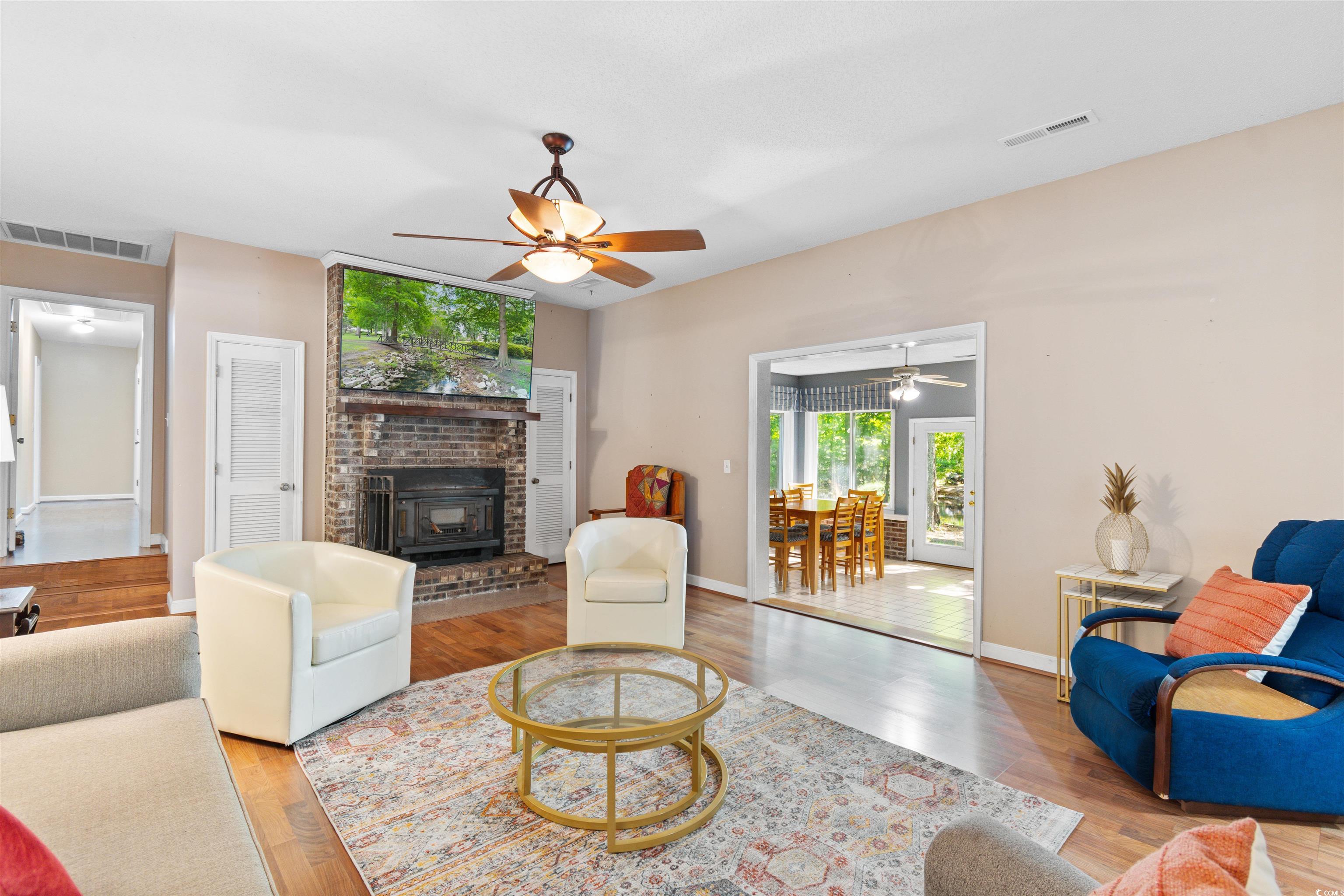 814 2nd Avenue Georgetown, SC 29440 - Photo 10 of 39 Living room with wood finished floors, ceiling fan, and a brick fireplace