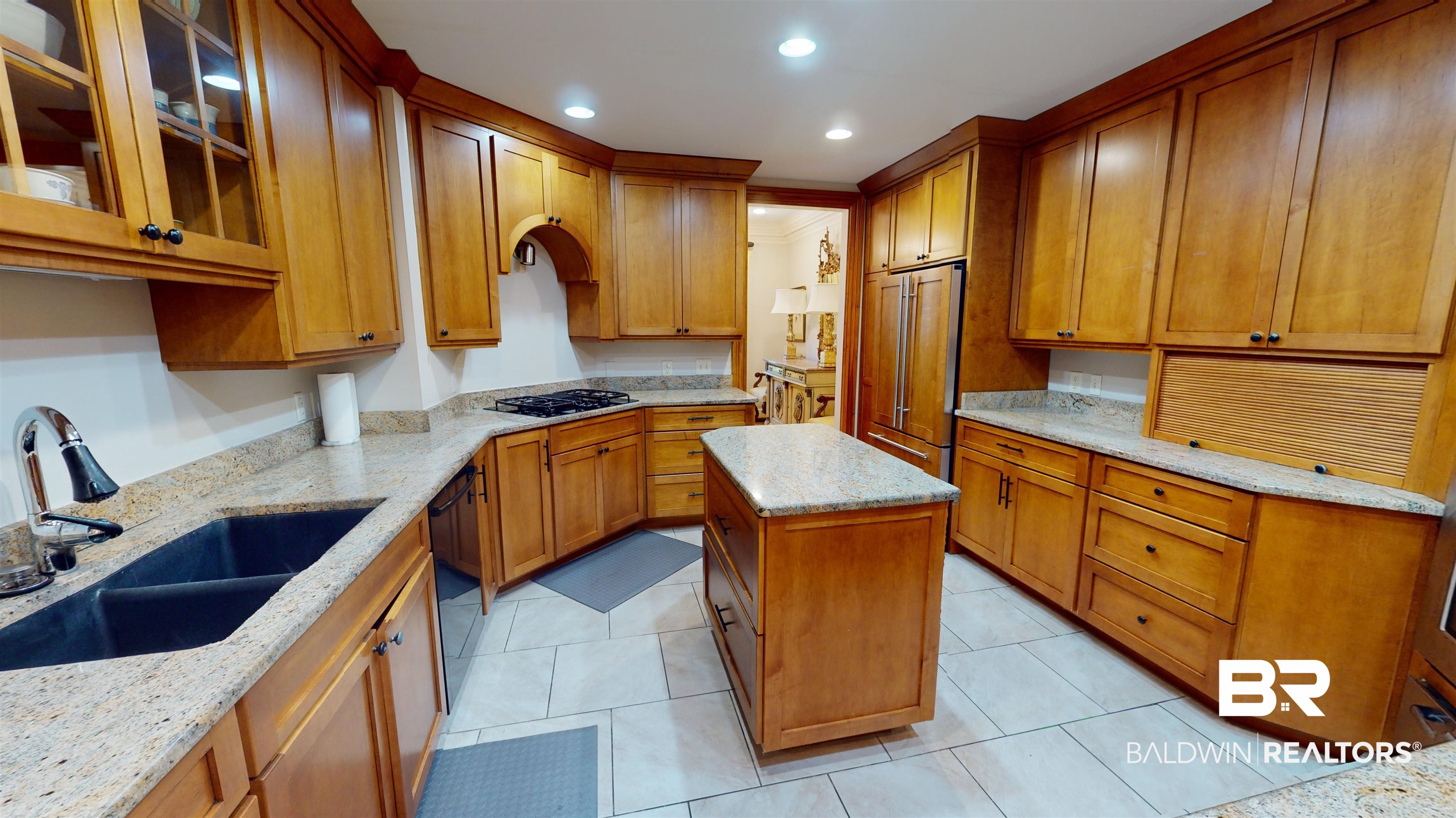 2404 Spring Hill Avenue, Unit 115 Mobile, AL 36607 - Photo 7 of 38 Kitchen with light tile patterned flooring, black appliances, sink, a kitchen island, and light stone counters
