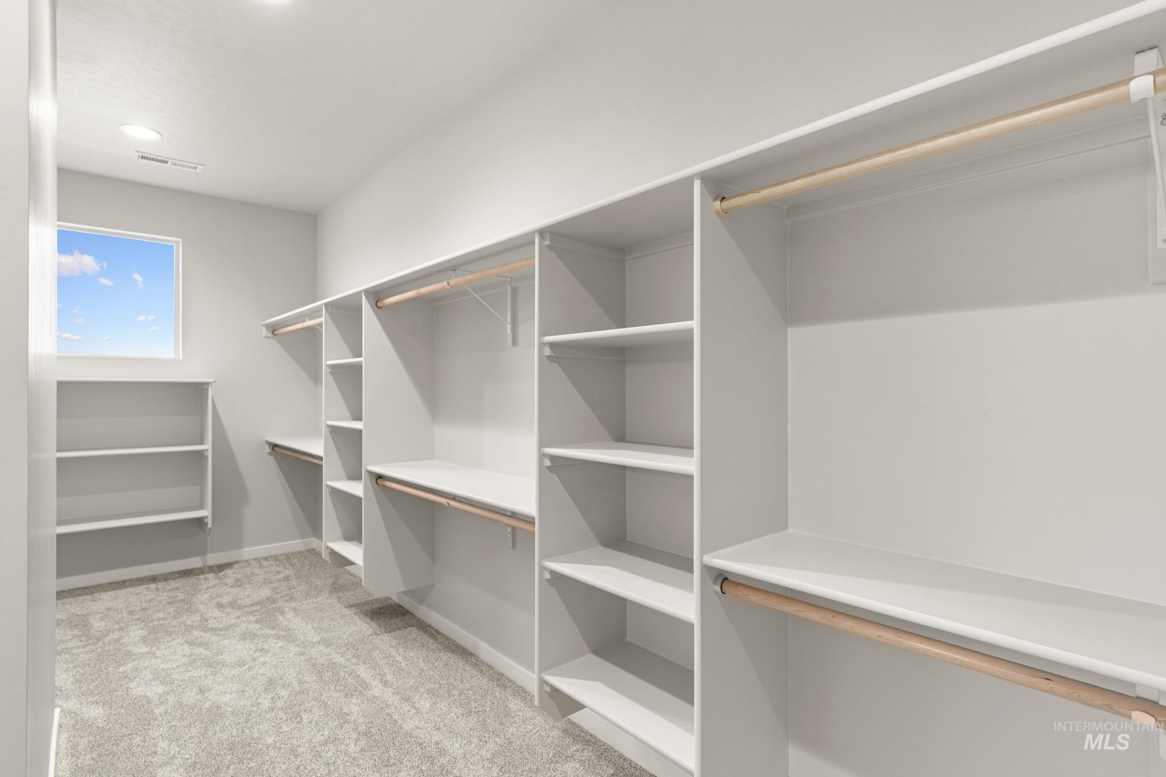 4227 East Rincon Drive Meridian, ID 83642 - Photo 18 of 31 Walk-in closet featuring built-in white shelving, multiple hanging rods, recessed lighting, and a window for natural light