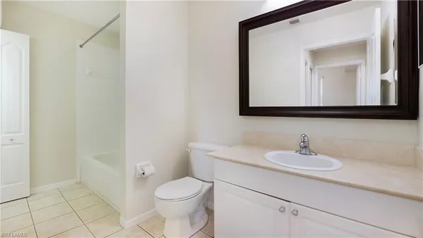 a bathroom with a toilet a sink a mirror and vanity