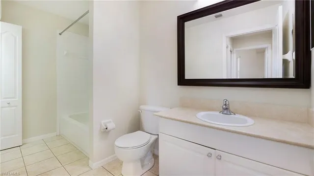 a bathroom with a toilet a sink a mirror and vanity
