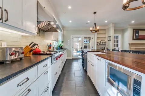 a large kitchen with stainless steel appliances lots of counter space cabinets and a wooden floor