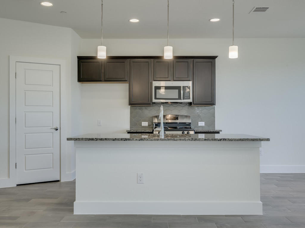 12327 Maypole Bend Austin, TX 78717 - Photo 10 of 30 a kitchen with stainless steel appliances a sink a stove a microwave and cabinets