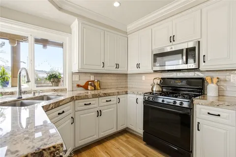 a kitchen with stainless steel appliances granite countertop a stove sink and cabinets
