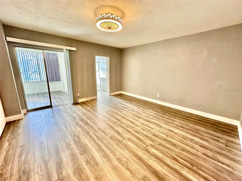 2431 Canadian Way, Unit 37 Clearwater, FL 33763 - Photo 17 of 46 an empty room with wooden floor and a window