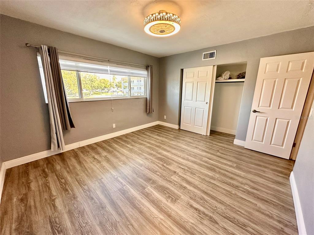 2431 Canadian Way, Unit 37 Clearwater, FL 33763 - Photo 25 of 46 a view of an empty room with wooden floor and a window