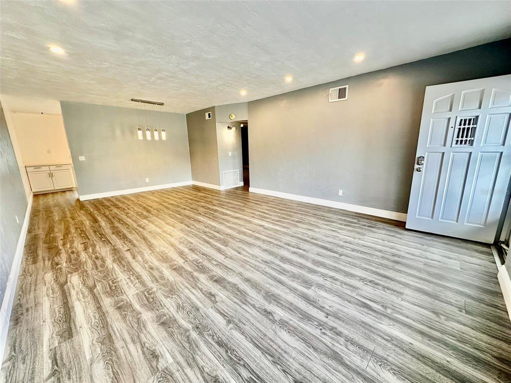 2431 Canadian Way, Unit 37 Clearwater, FL 33763 - Photo 4 of 46 a view of an empty room with wooden floor and entryway