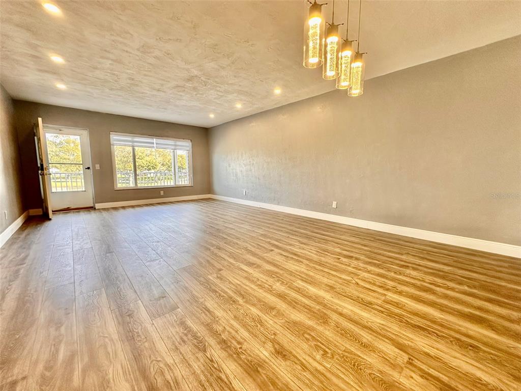 2431 Canadian Way, Unit 37 Clearwater, FL 33763 - Photo 6 of 46 wooden floor in an empty room with a window