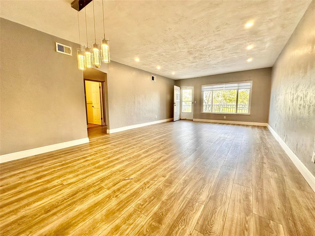 2431 Canadian Way, Unit 37 Clearwater, FL 33763 - Photo 7 of 46 a view of an empty room with wooden floor and a window