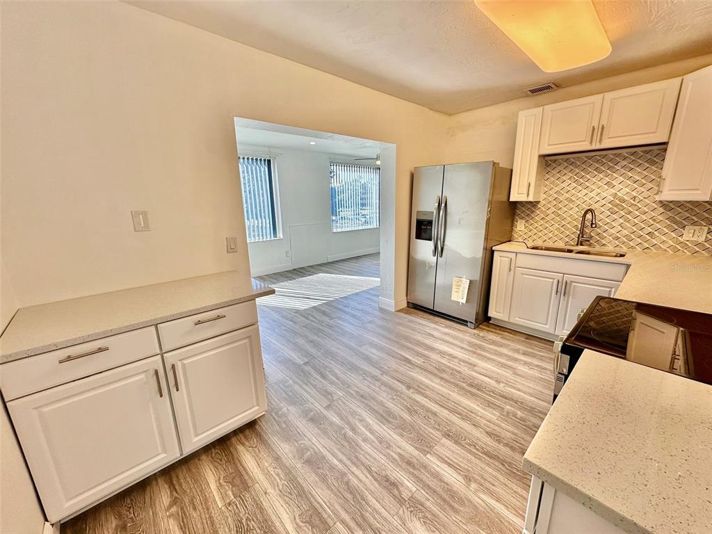 2431 Canadian Way, Unit 37 Clearwater, FL 33763 - Photo 9 of 46 a kitchen with granite countertop white cabinets and refrigerator