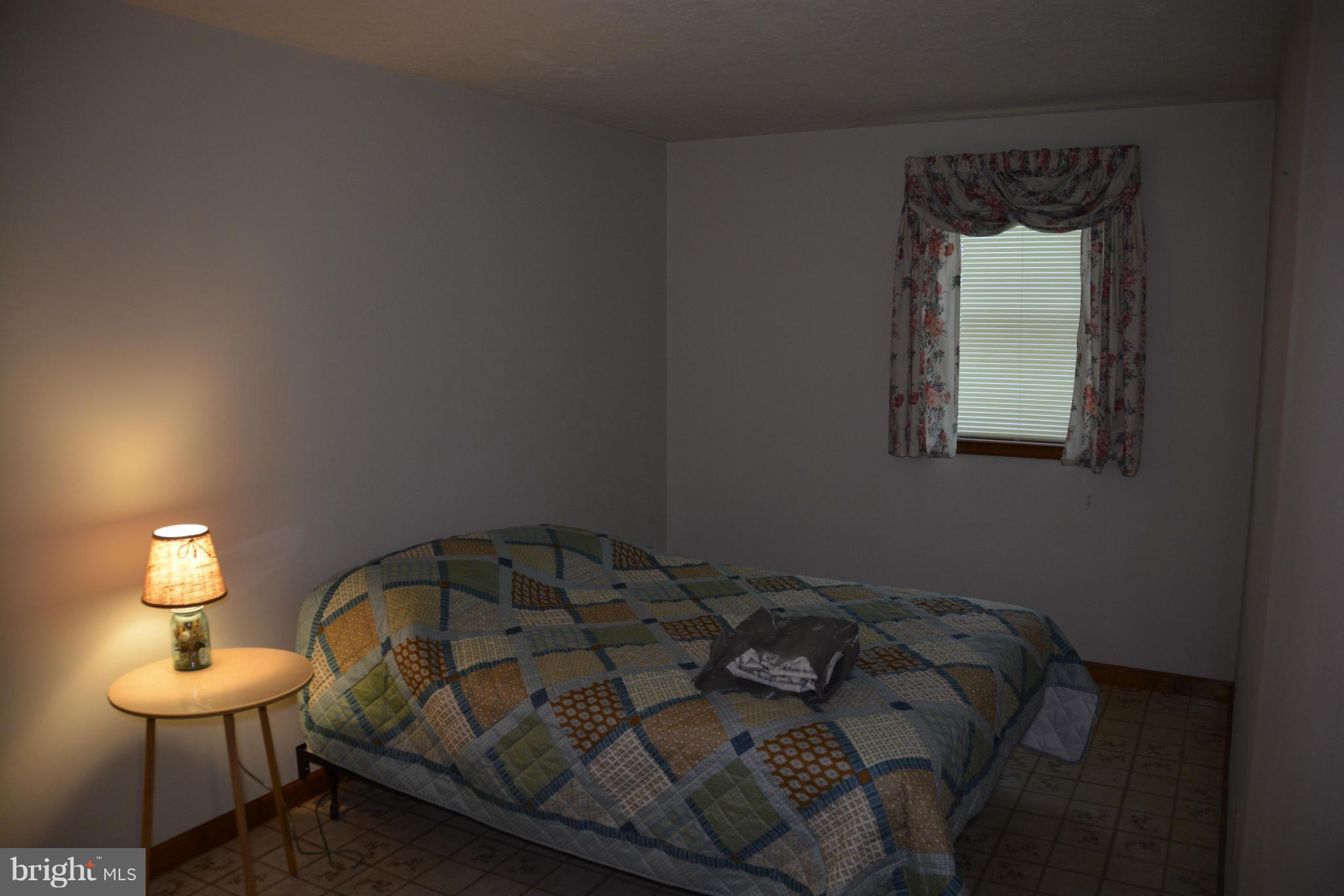 523 Sawlog Road Gore, VA 22637 - Photo 11 of 30 a bedroom with a bed and a lamp on table