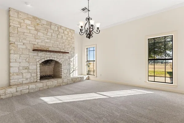 an empty room with windows and fireplace