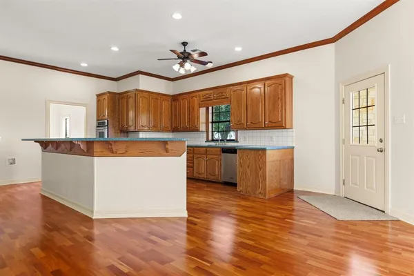a large kitchen with cabinets and wooden floor