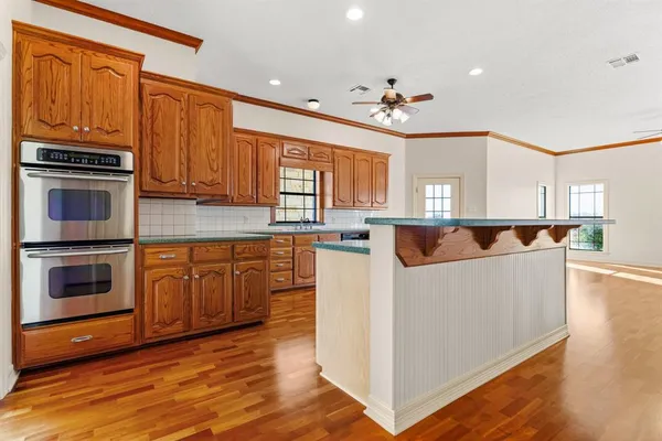 a living room with stainless steel appliances kitchen island granite countertop a stove and a refrigerator
