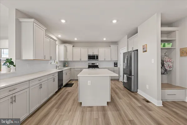 a kitchen with a sink a stove top oven and white cabinets