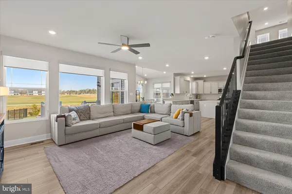 a living room with furniture and a ceiling fan