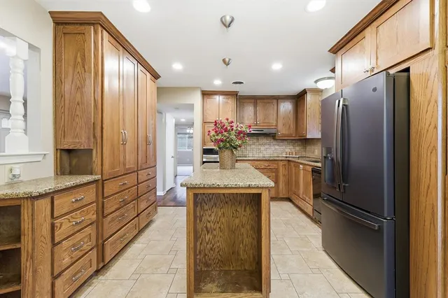 a kitchen with stainless steel appliances granite countertop a refrigerator and a sink