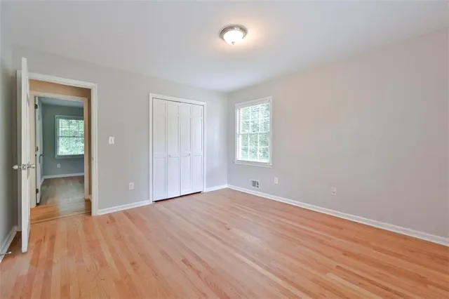 an empty room with windows and closet