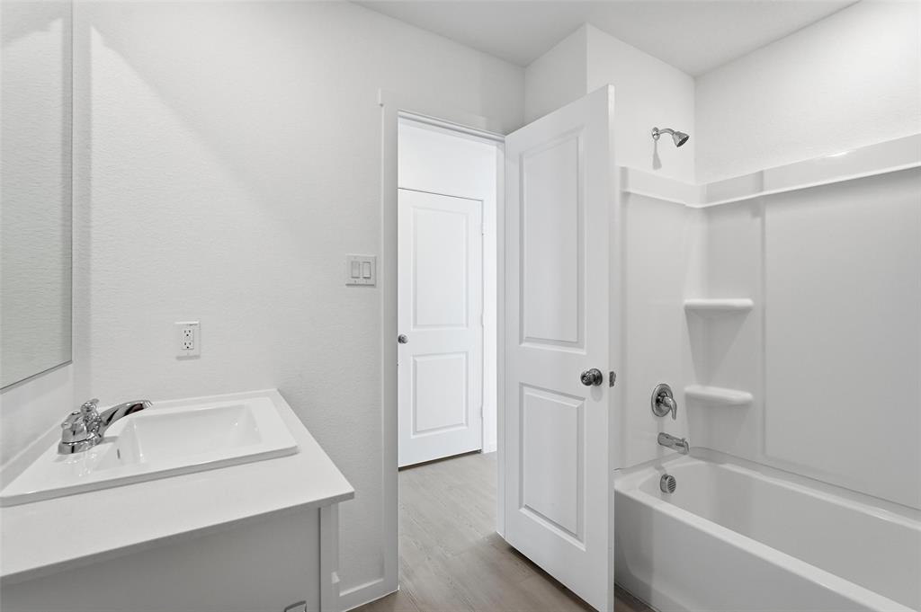 3919 Selawik Street Sherman, TX 75090 - Photo 15 of 21 a bathroom with a bathtub a sink and a mirror