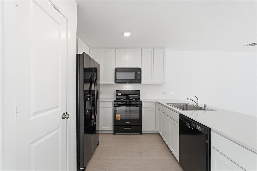 3919 Selawik Street Sherman, TX 75090 - Photo 4 of 21 a kitchen with a sink cabinets and stainless steel appliances