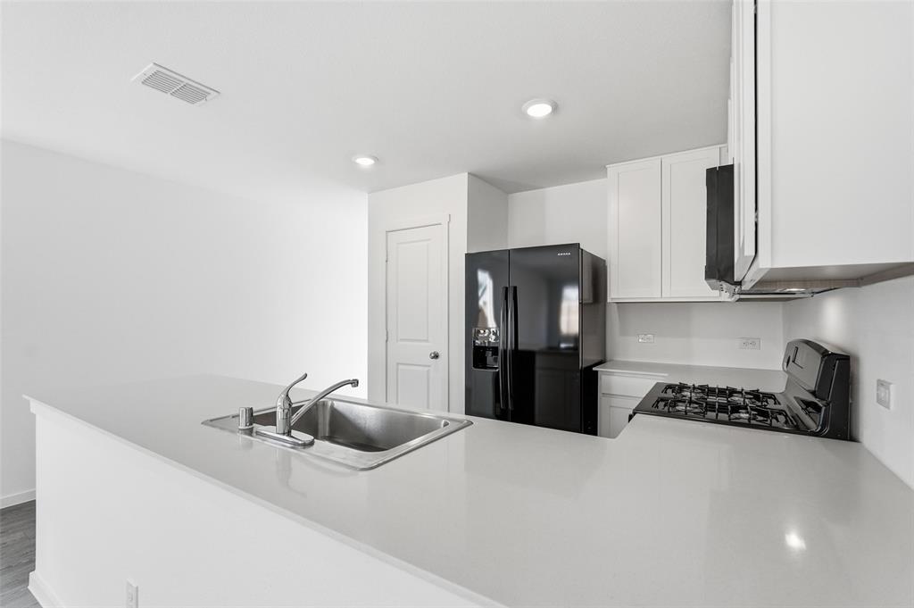 3919 Selawik Street Sherman, TX 75090 - Photo 5 of 21 a kitchen with refrigerator and stove