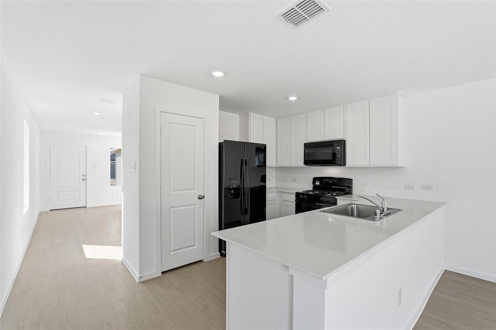 3919 Selawik Street Sherman, TX 75090 - Photo 7 of 21 a kitchen with stainless steel appliances a refrigerator sink and microwave