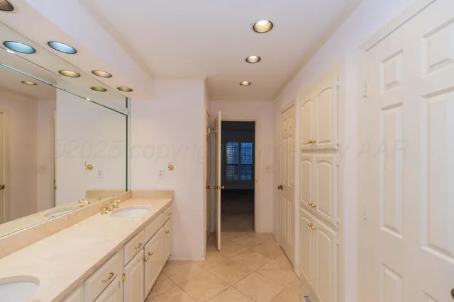 a spacious bathroom with a double vanity sink and a mirror
