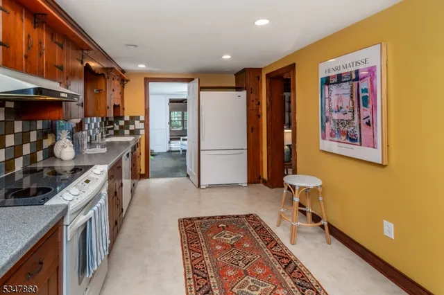 a kitchen with stainless steel appliances granite countertop a refrigerator a stove and a sink