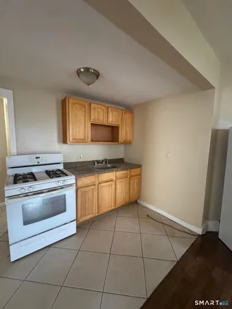 a kitchen with granite countertop a stove a sink and a microwave