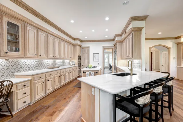a kitchen with granite countertop a table chairs sink and cabinets