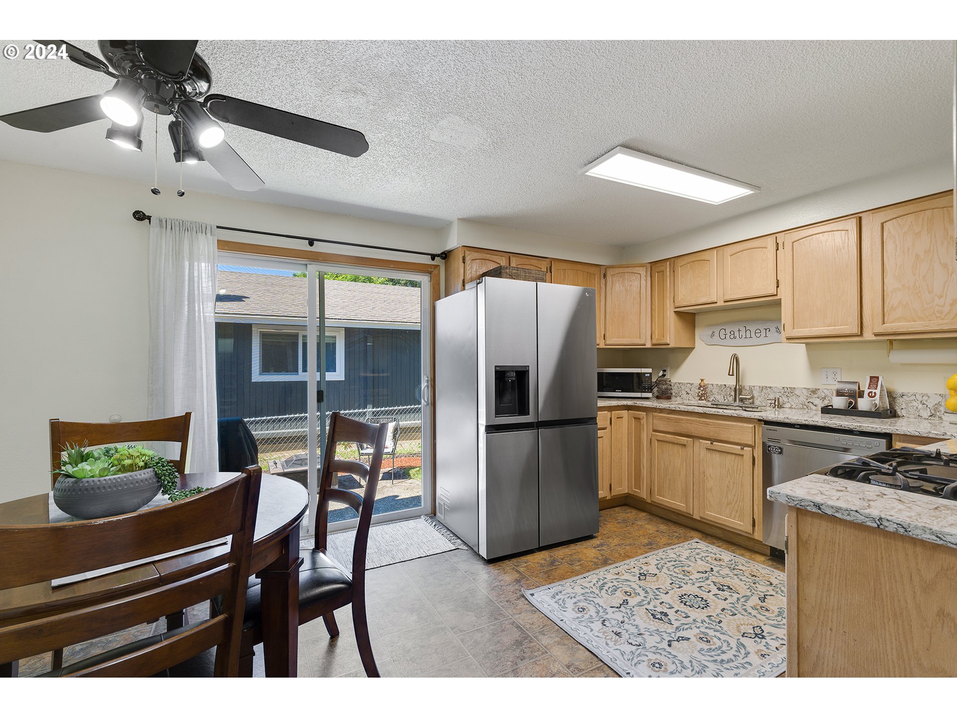 7946 Southeast 103rd Avenue Portland, OR 97266 - Photo 12 of 32 a kitchen with refrigerator and cabinets