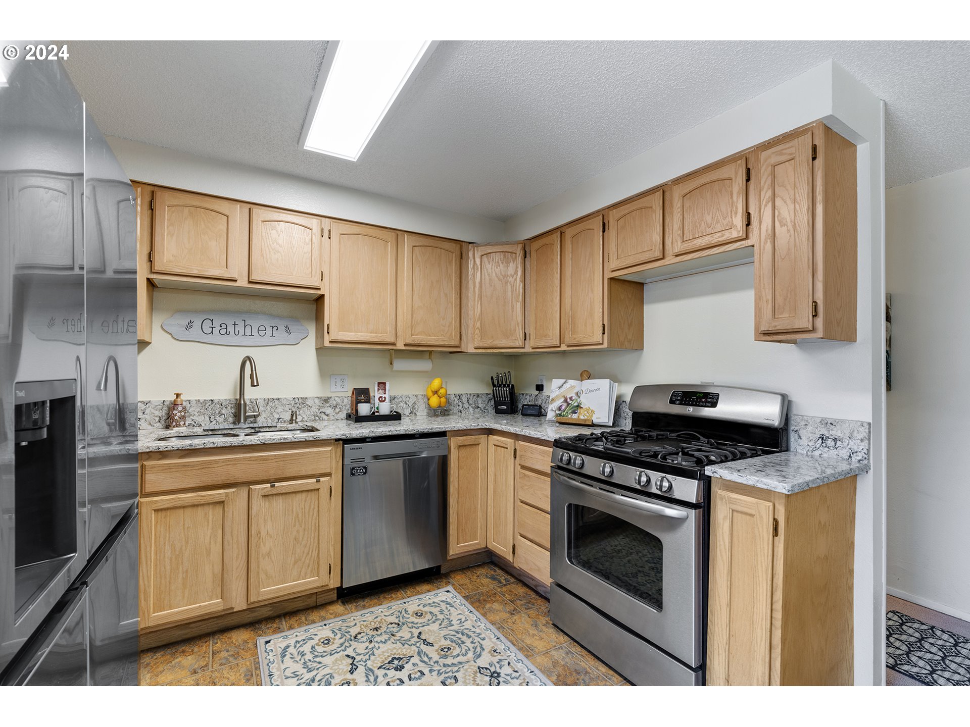7946 Southeast 103rd Avenue Portland, OR 97266 - Photo 13 of 32 a kitchen with stainless steel appliances granite countertop a stove sink and cabinets