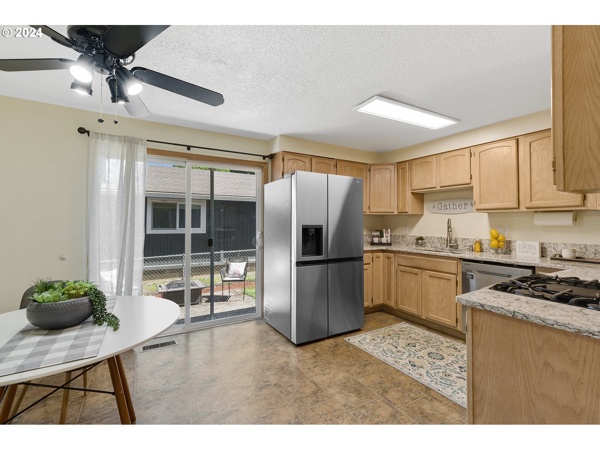 7946 Southeast 103rd Avenue Portland, OR 97266 - Photo 32 of 32 a kitchen with a refrigerator a stove a sink a dining table and chairs with wooden floor