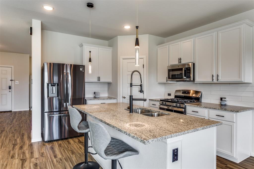 516 Palmito Ranch Road Fort Worth, TX 76131 - Photo 15 of 32 a kitchen with stainless steel appliances granite countertop a sink refrigerator and microwave