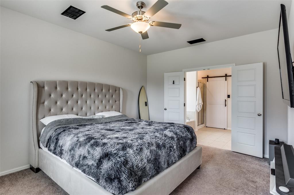 516 Palmito Ranch Road Fort Worth, TX 76131 - Photo 17 of 32 a bedroom with a large bed and a chandelier