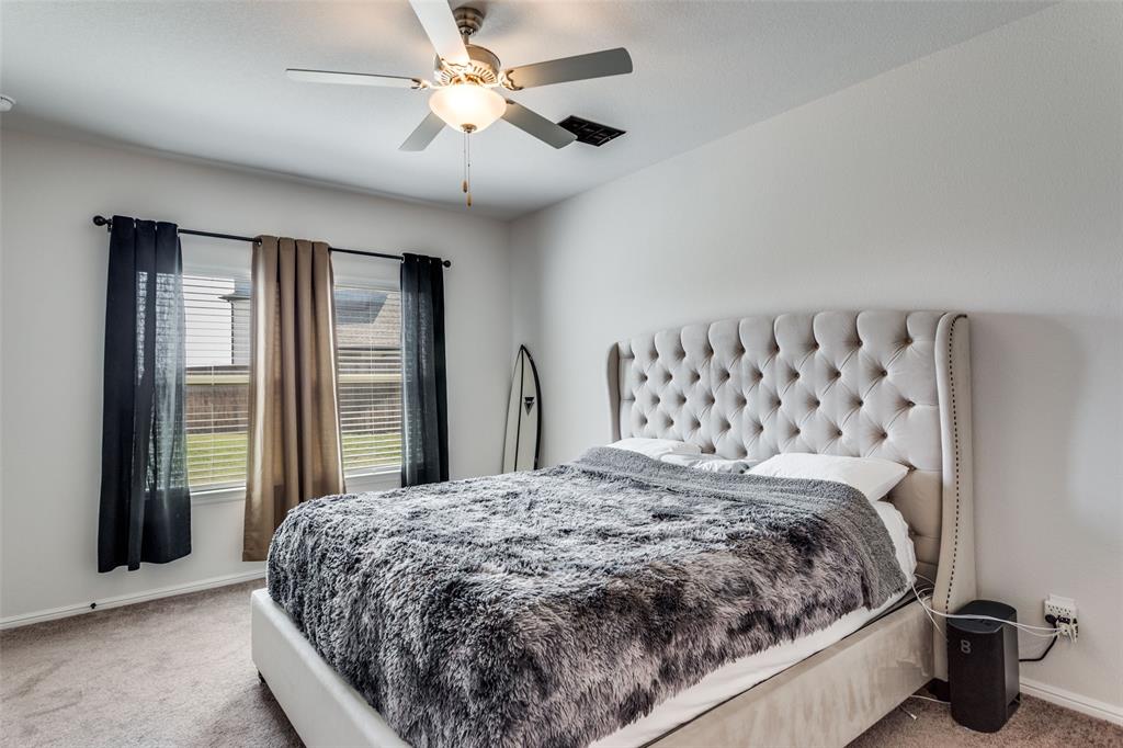516 Palmito Ranch Road Fort Worth, TX 76131 - Photo 18 of 32 a bedroom with a large bed and a chandelier fan