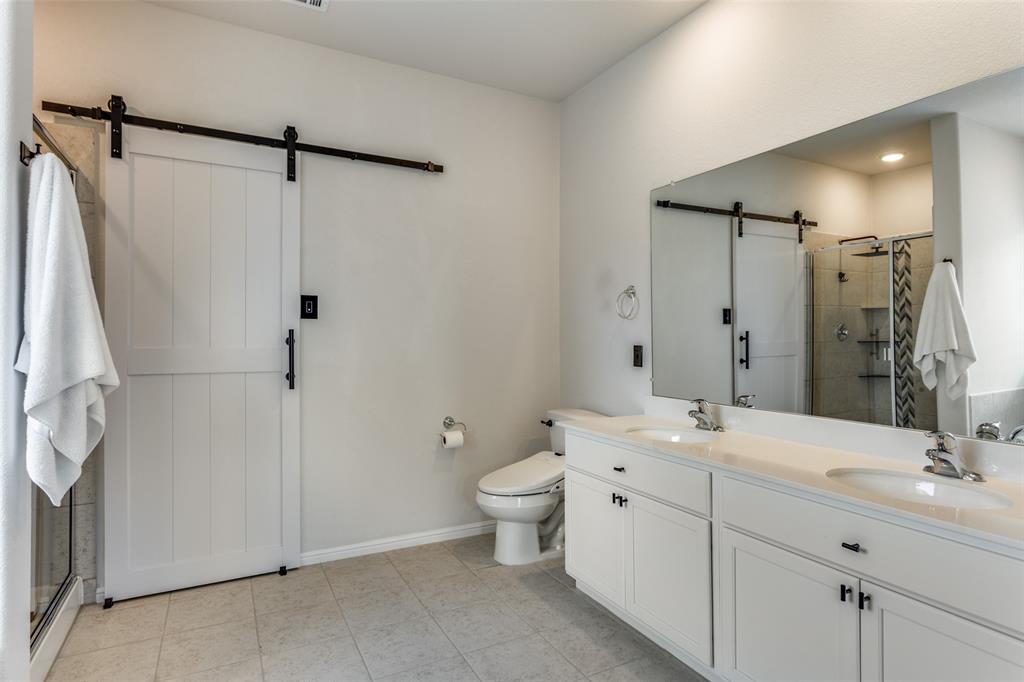 516 Palmito Ranch Road Fort Worth, TX 76131 - Photo 19 of 32 a bathroom with a double vanity sink toilet mirror and shower